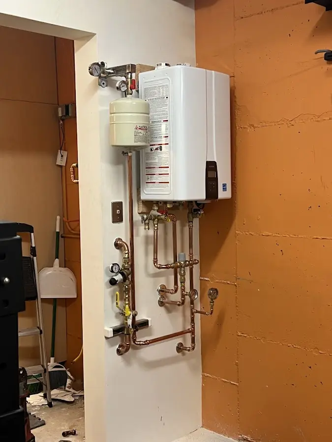 Plumbing technician inspecting water heater connections in Lander
